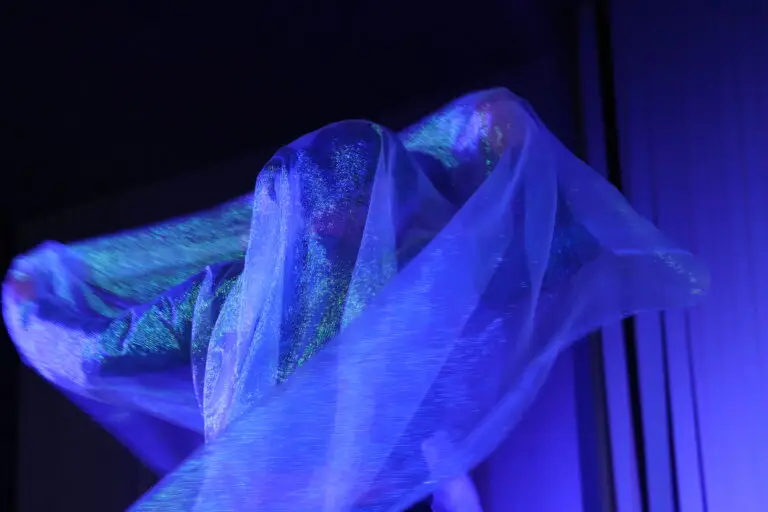 Translucent blue fabric illuminated in dark lighting
