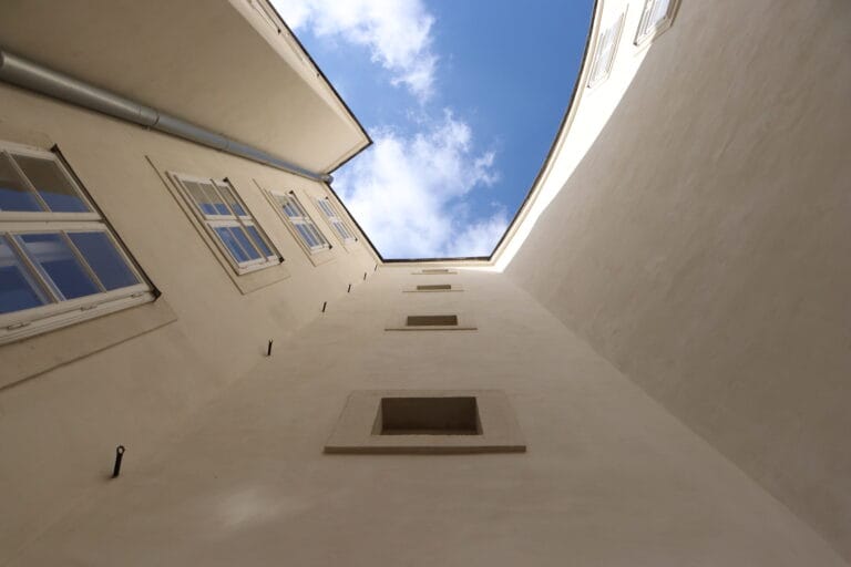 Upward view of buildings framing a blue sky