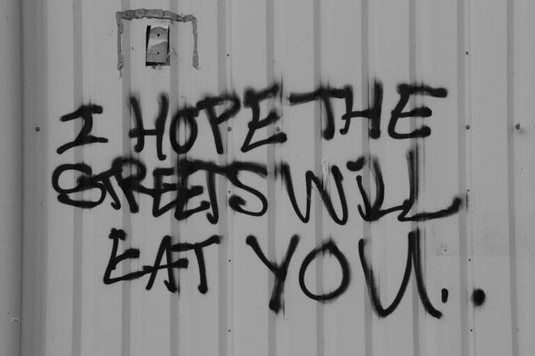 Graffiti text reading “Hope the streets will eat you”