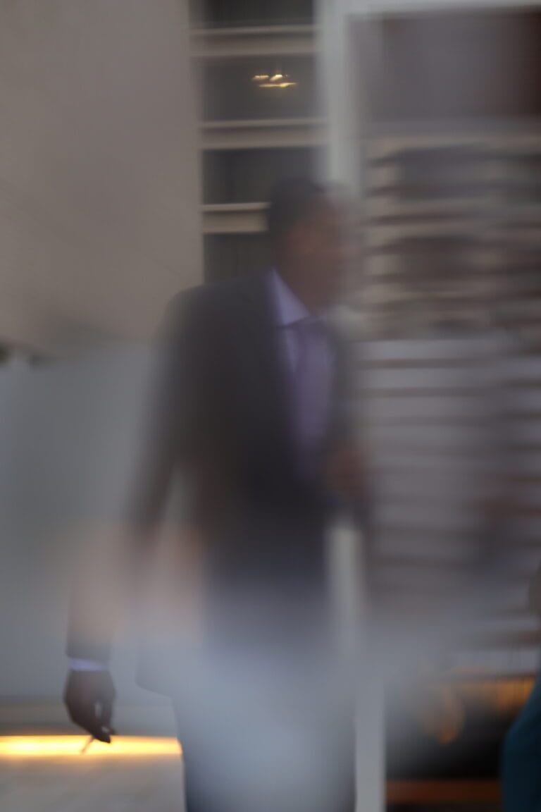 Blurred figure in formal clothing walking indoors